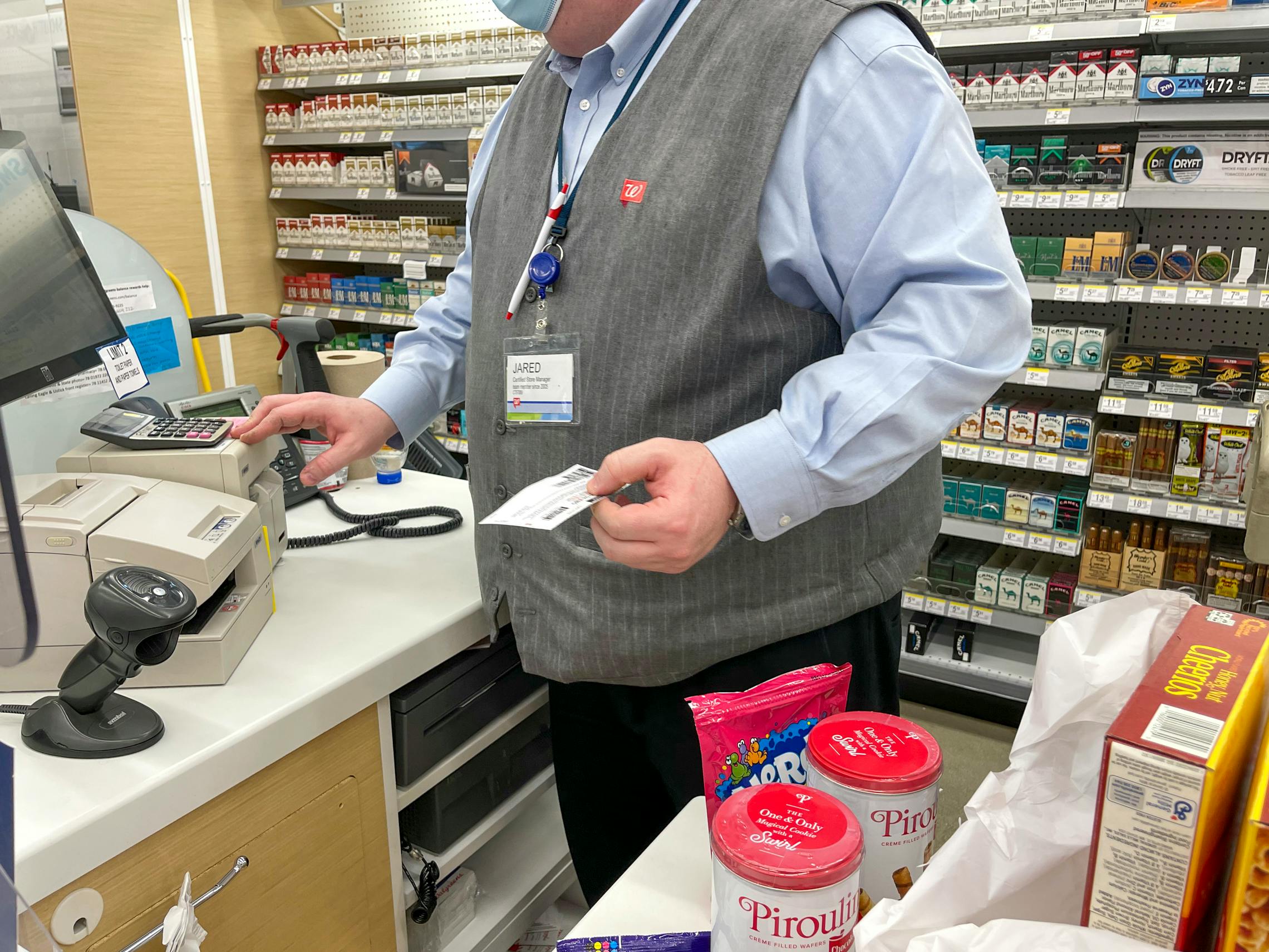 A Walgreens employee at checkout ringing up purchases.