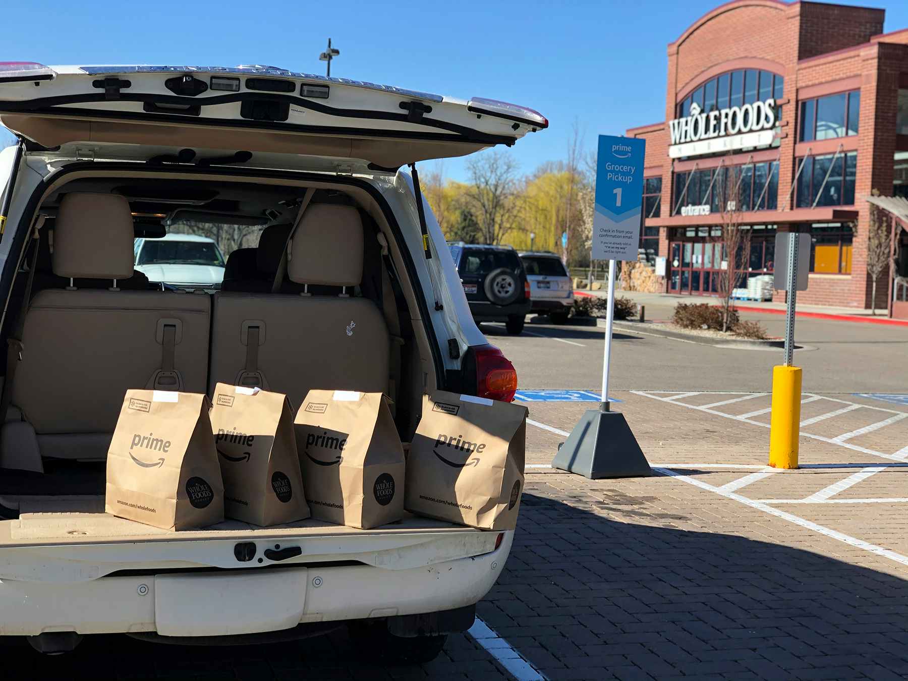 SUV with trunk open filled with Amazon Prime Now Whole Foods groceries