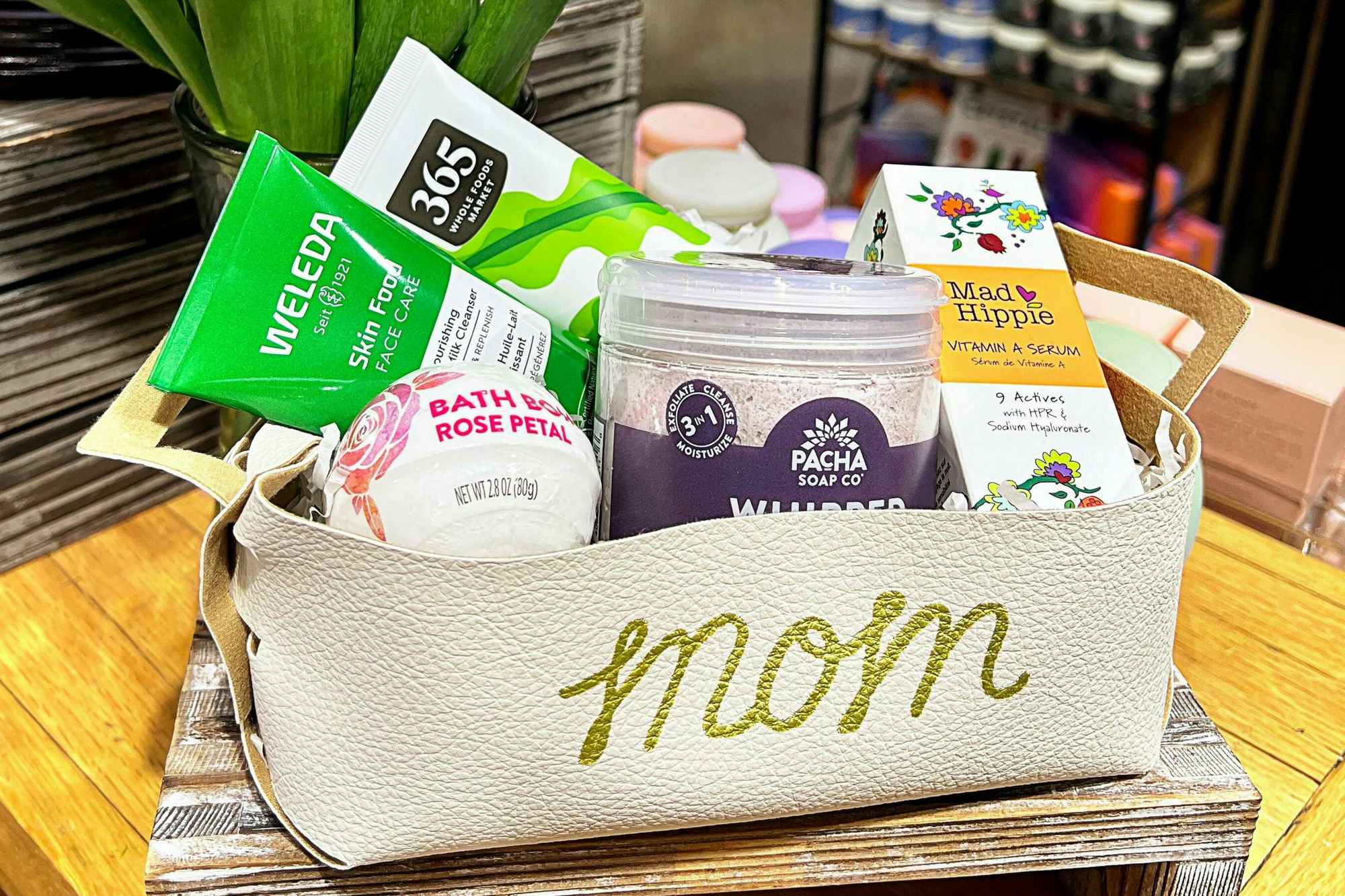 A personalized leather gift basket with spa items from Whole Foods inside