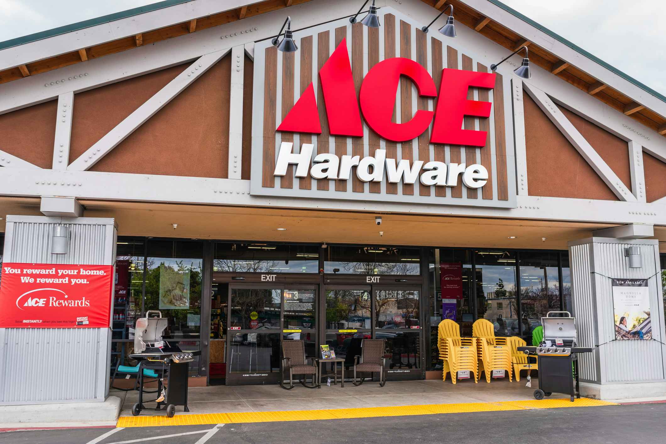 An Ace Hardware store entrance with outdoor chairs and grills on display