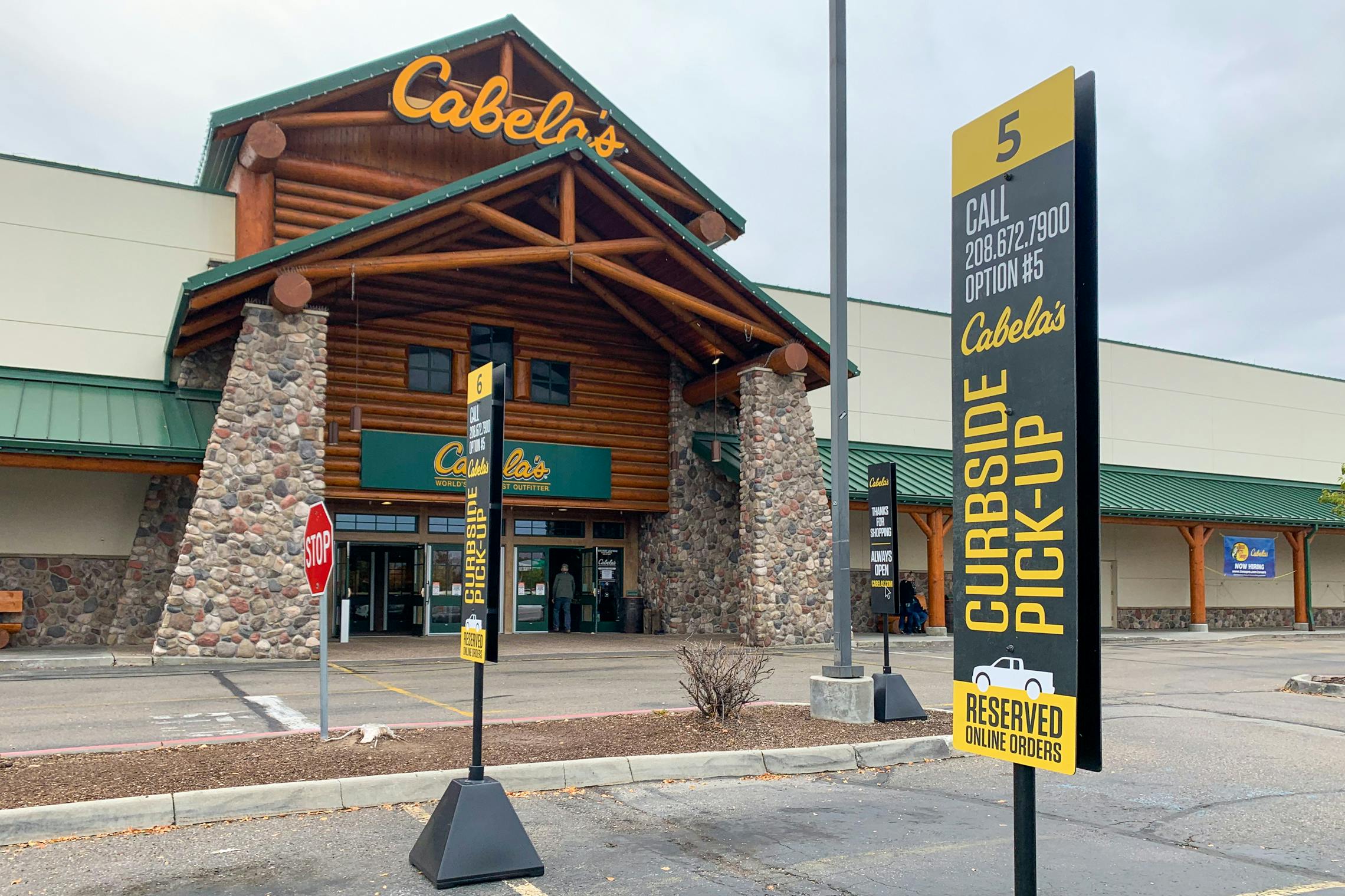 Cabela's storefront with curbside pickup sign in the parking lot.
