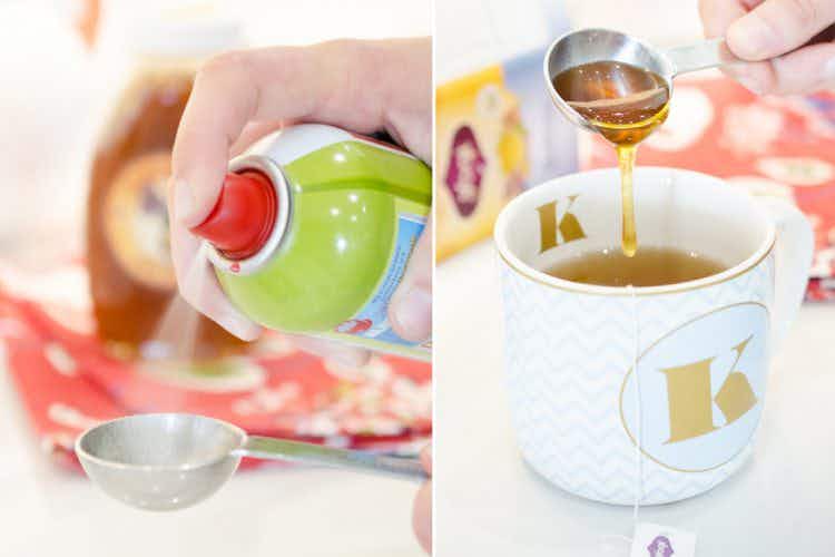 Person-spraying-nonstick-spray-into-measuring-spoon-next-to-a-measuring-spoon-pouring-honey-into-tea-cup
