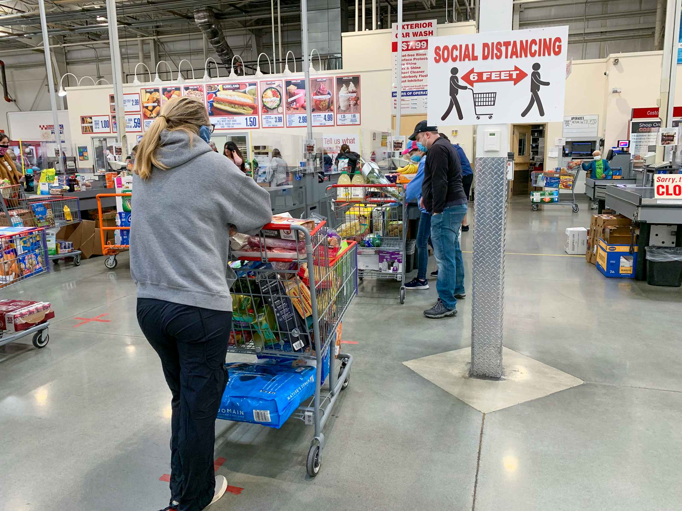 Costco checkout line with social distancing sign.