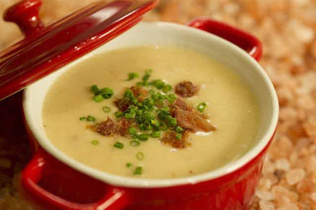 cheese soup in abowl with chives and bacon on top