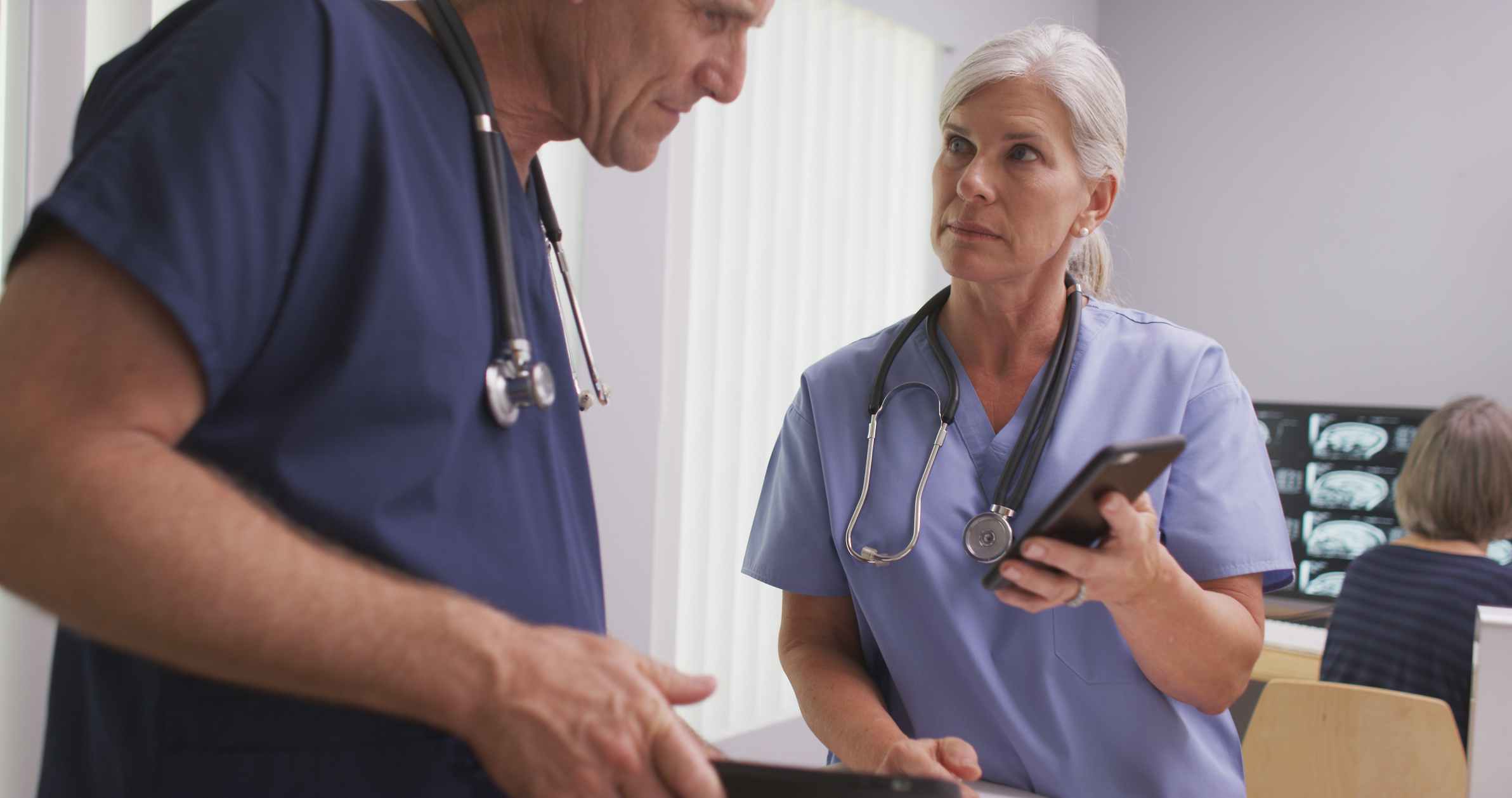 Nurse and doctor look at smartphone