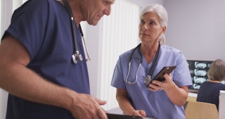 Nurse and doctor look at smartphone