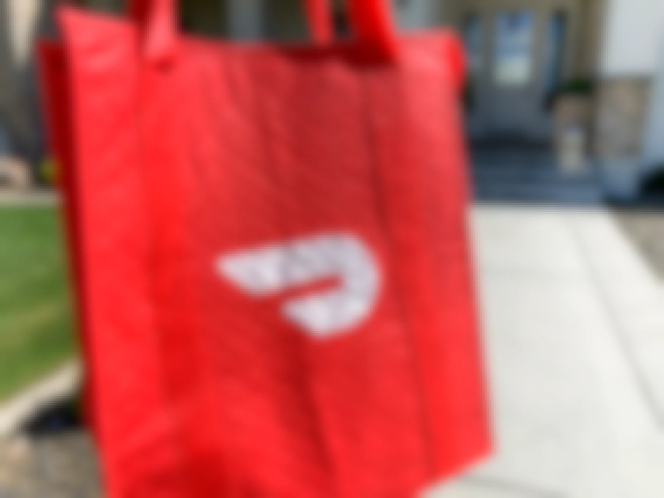 A doordash bag in front of a house.