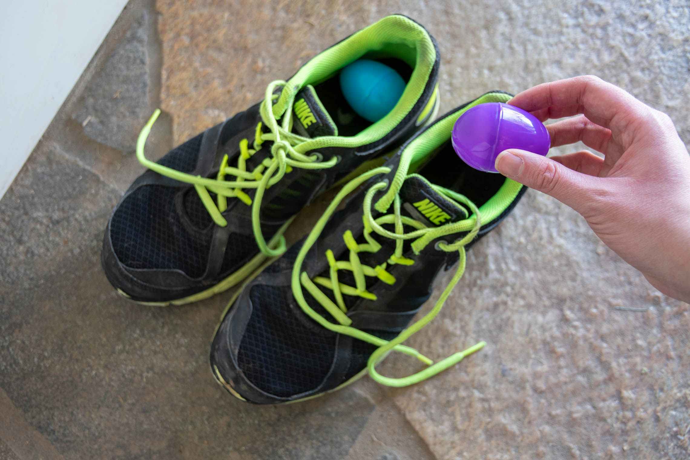 Running shoes with two plastic Easter eggs inside them.