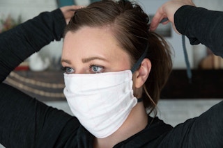 A woman trying on a fabric face mask.