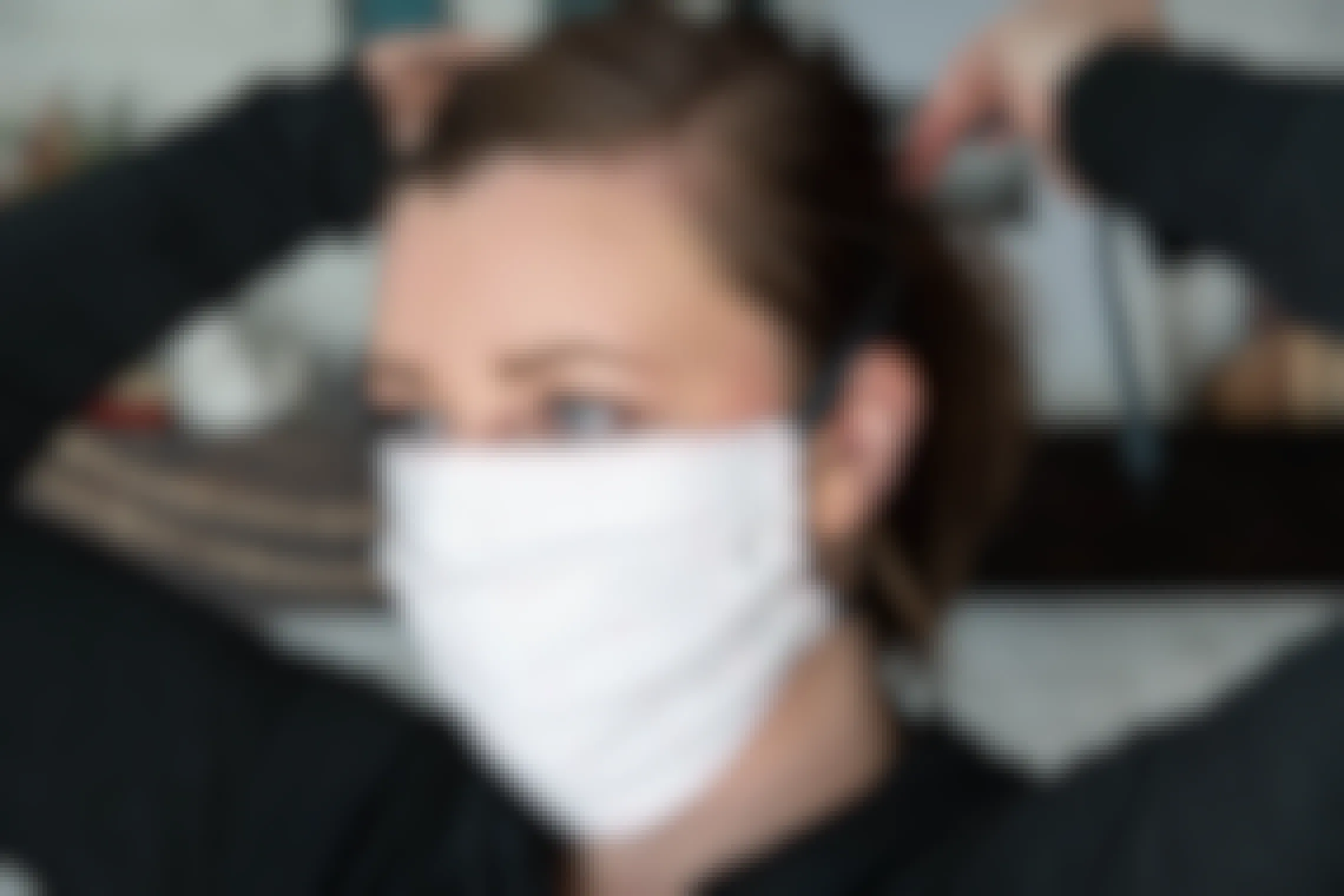 A woman trying on a fabric face mask.