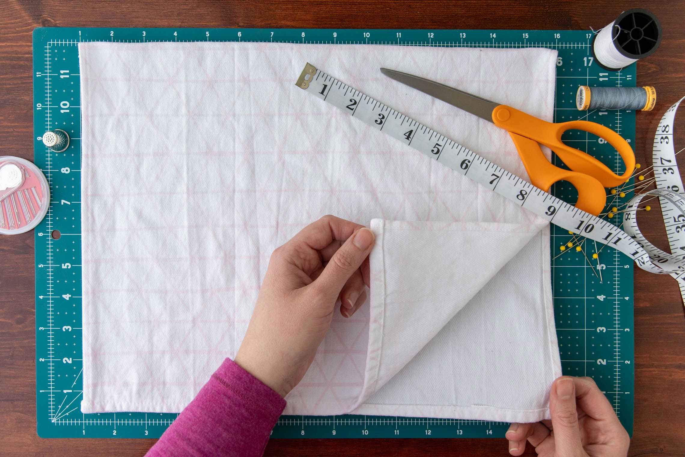 Model folding fabric in half.