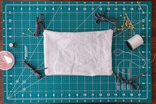 Mask has been turned right-side out by using the opening, and it's laying flat with ties standing out on all four corners.