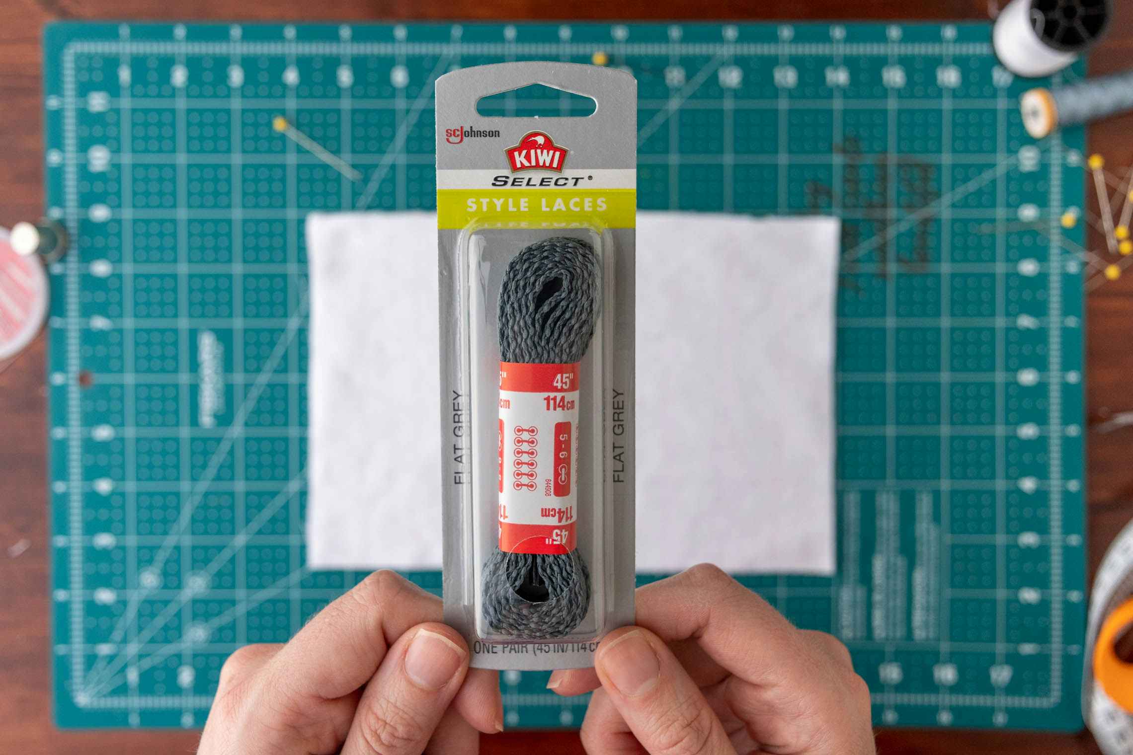 A package of flat shoelaces with the fabric in the background.