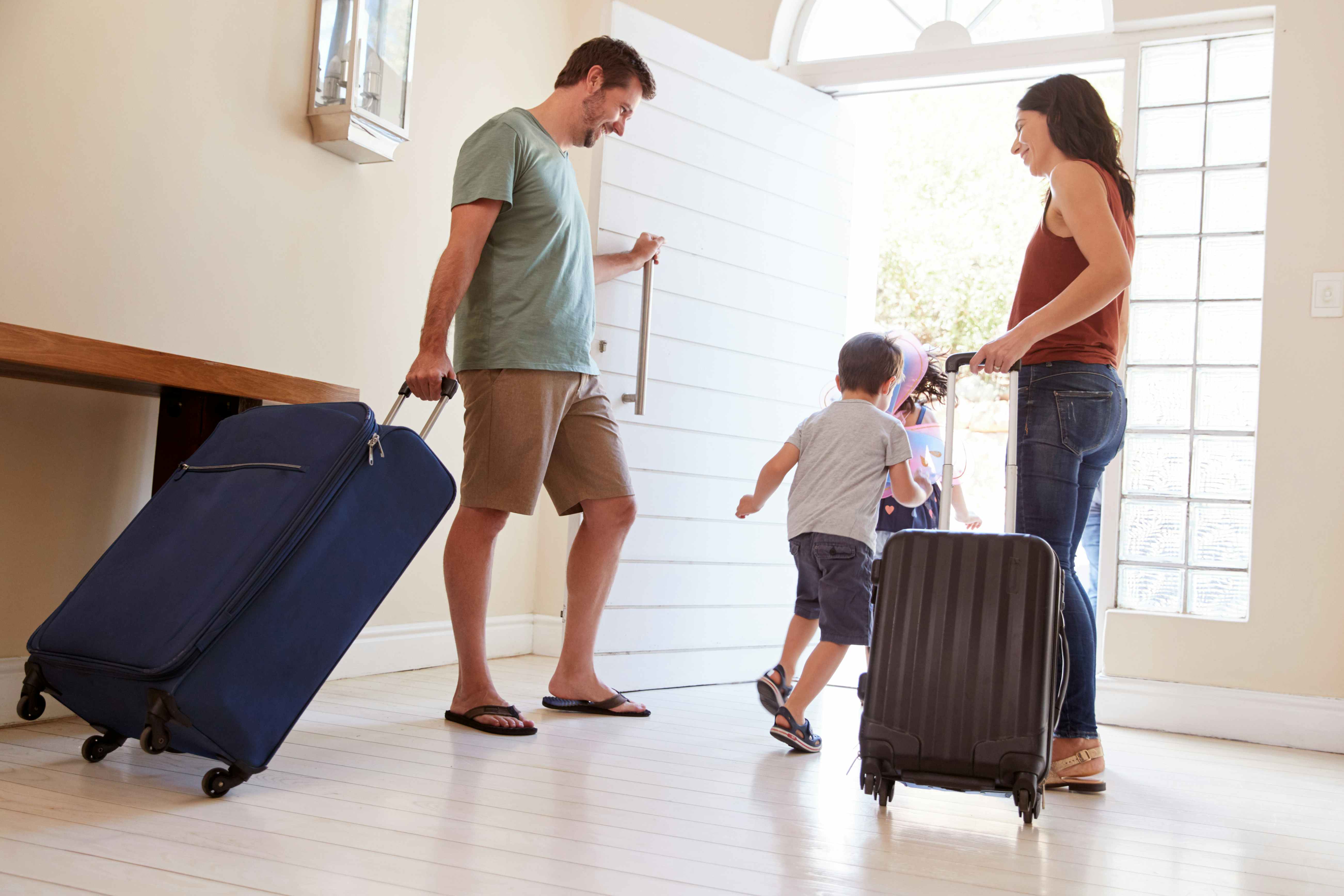 family taking luggage out the door