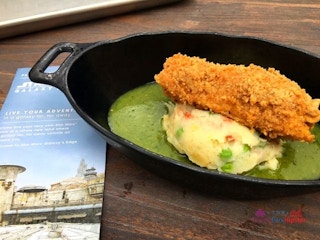 Fried Chicken on top of potatoes in a cast iron dish