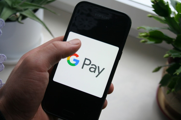 hand holds phone with Gpay app on screen