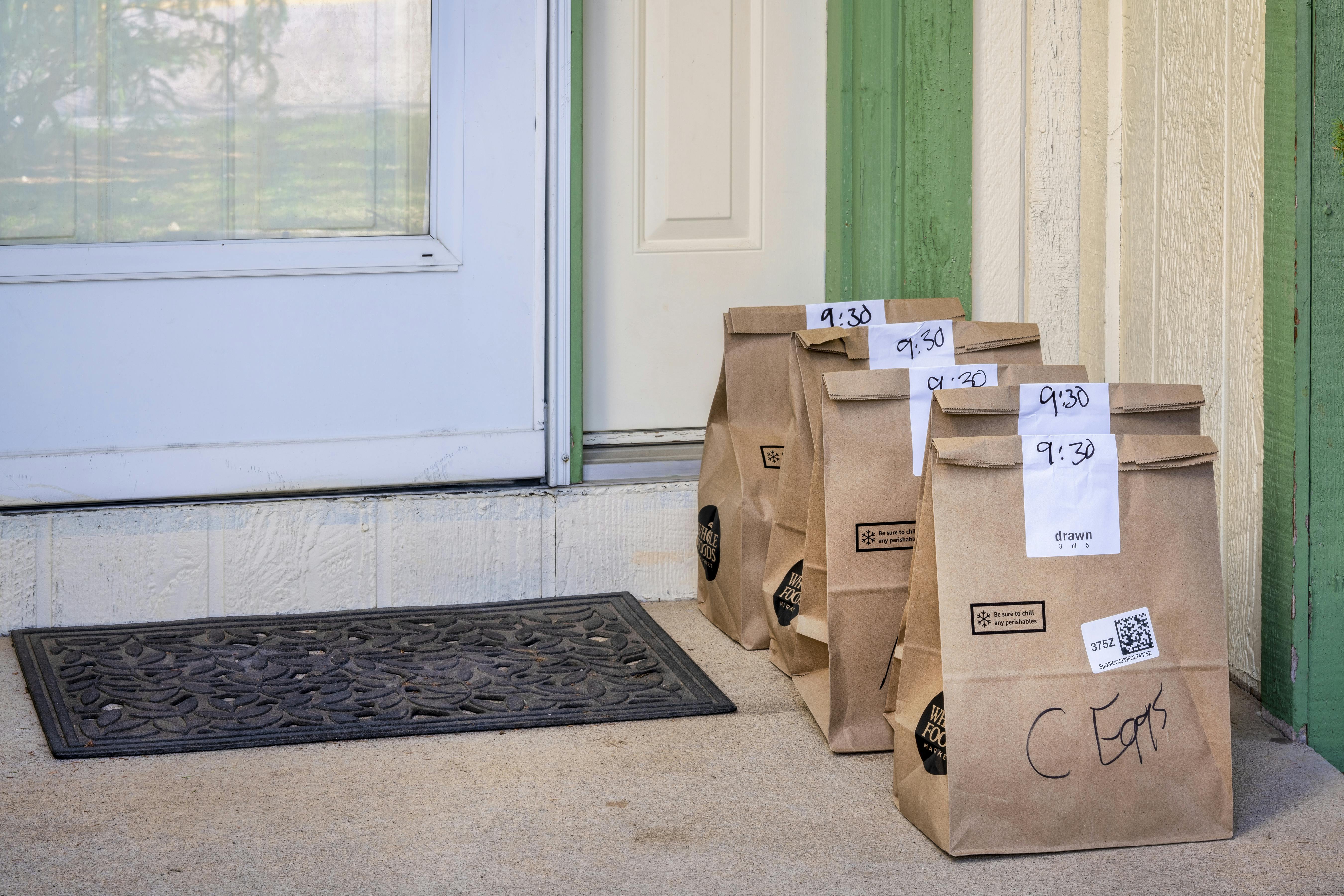 brown bags sitting outside the door of a home.