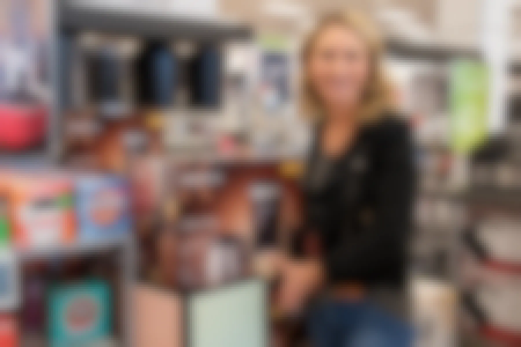 Woman smiling for the camera while holding a Keurig box inside Kohls.