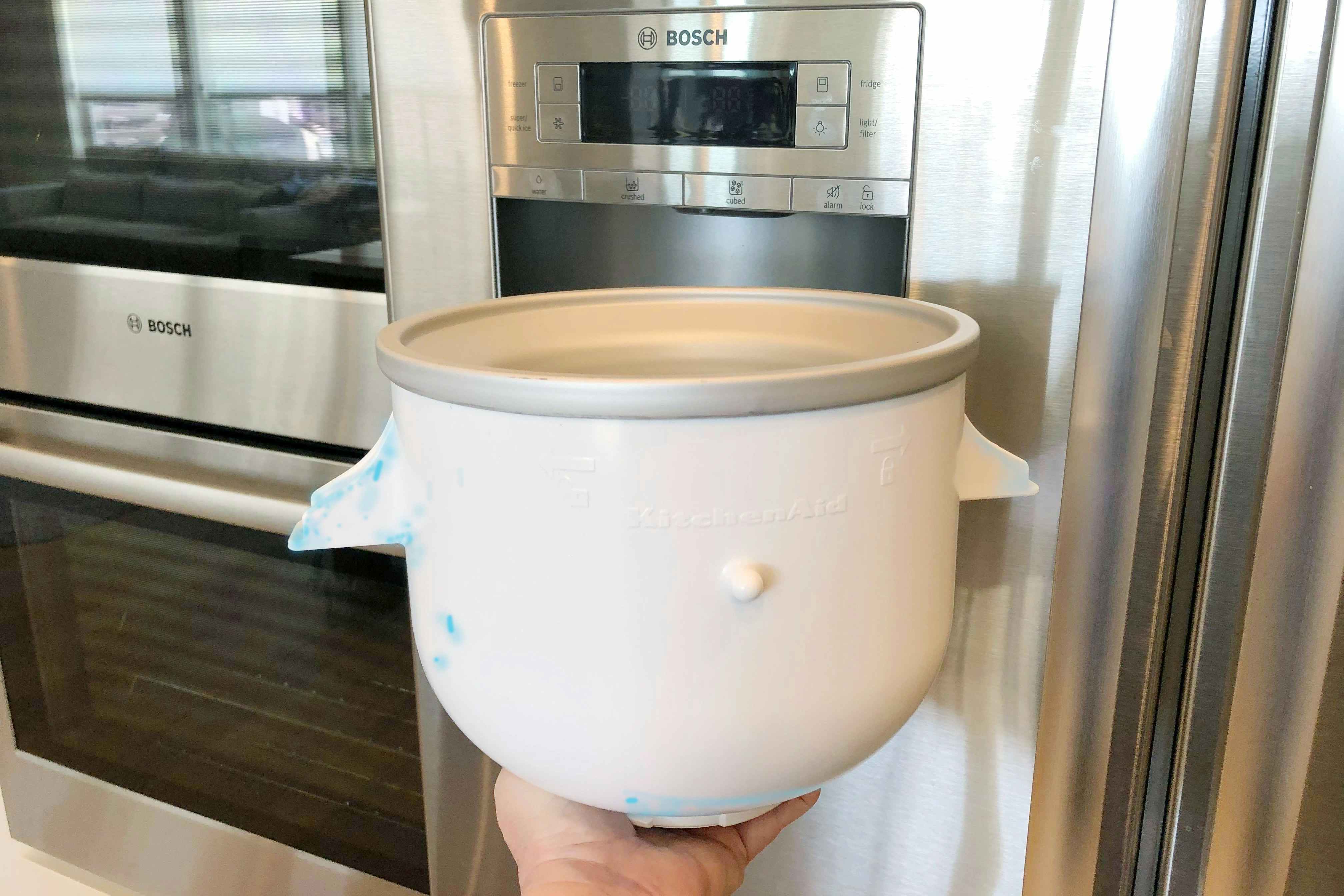 A kitchenaid ice cream attachment bowl with blue goo on the side.