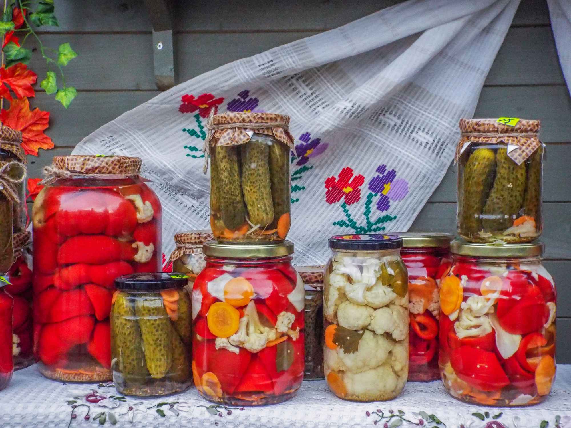 Autumn seasonal picture with delicious romanian home made assorted pickles traditional packaged in jars