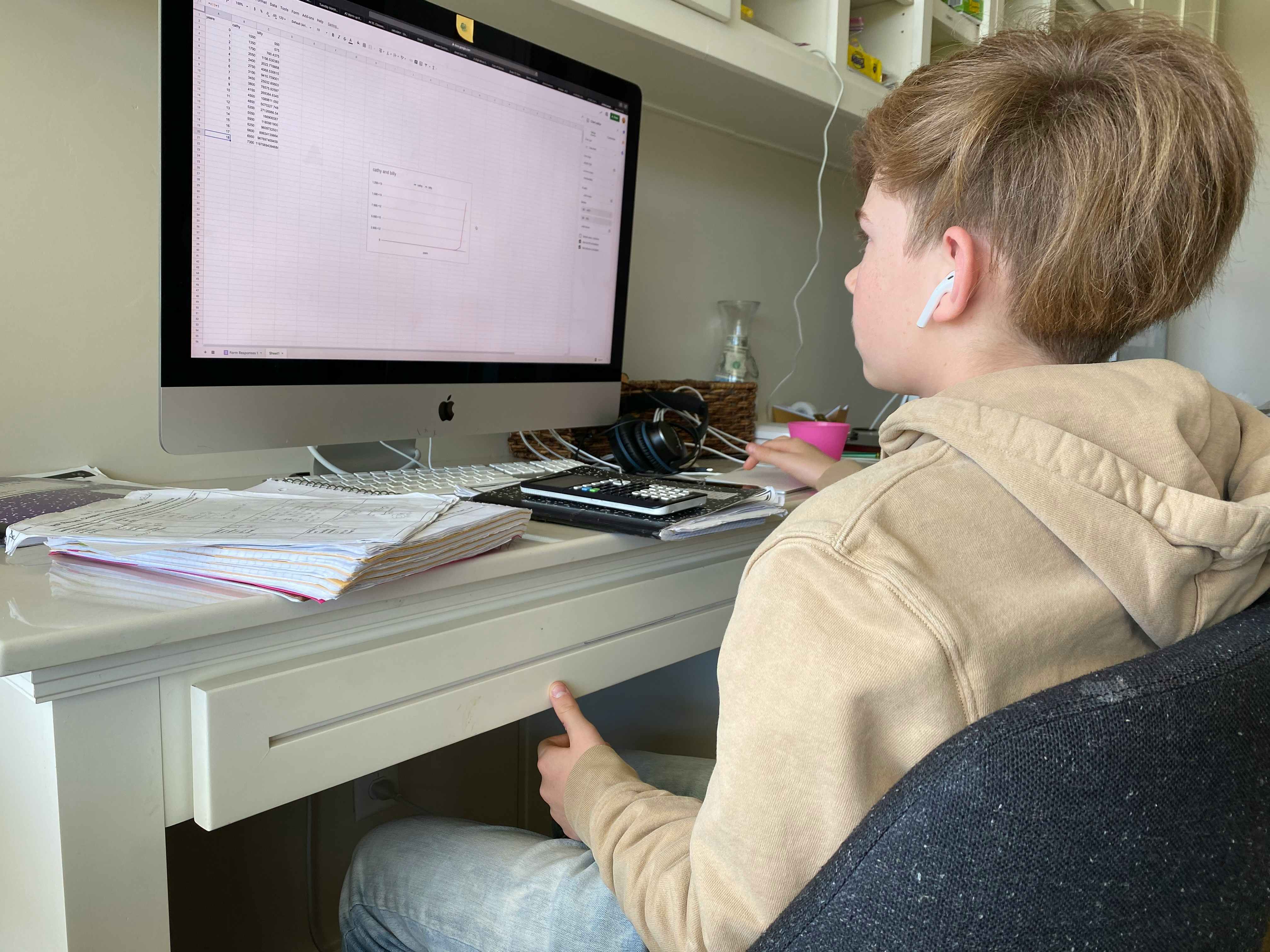 School age boy doing school work on desktop computer at home.