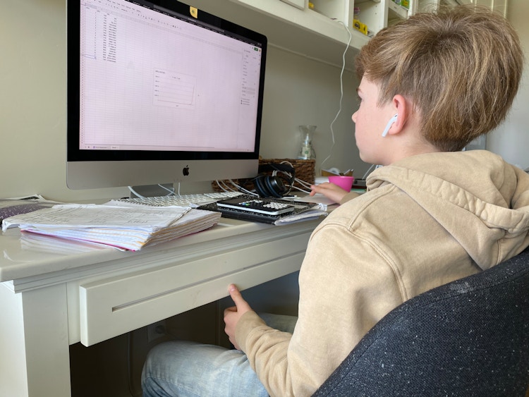 School age boy doing school work on desktop computer at home.