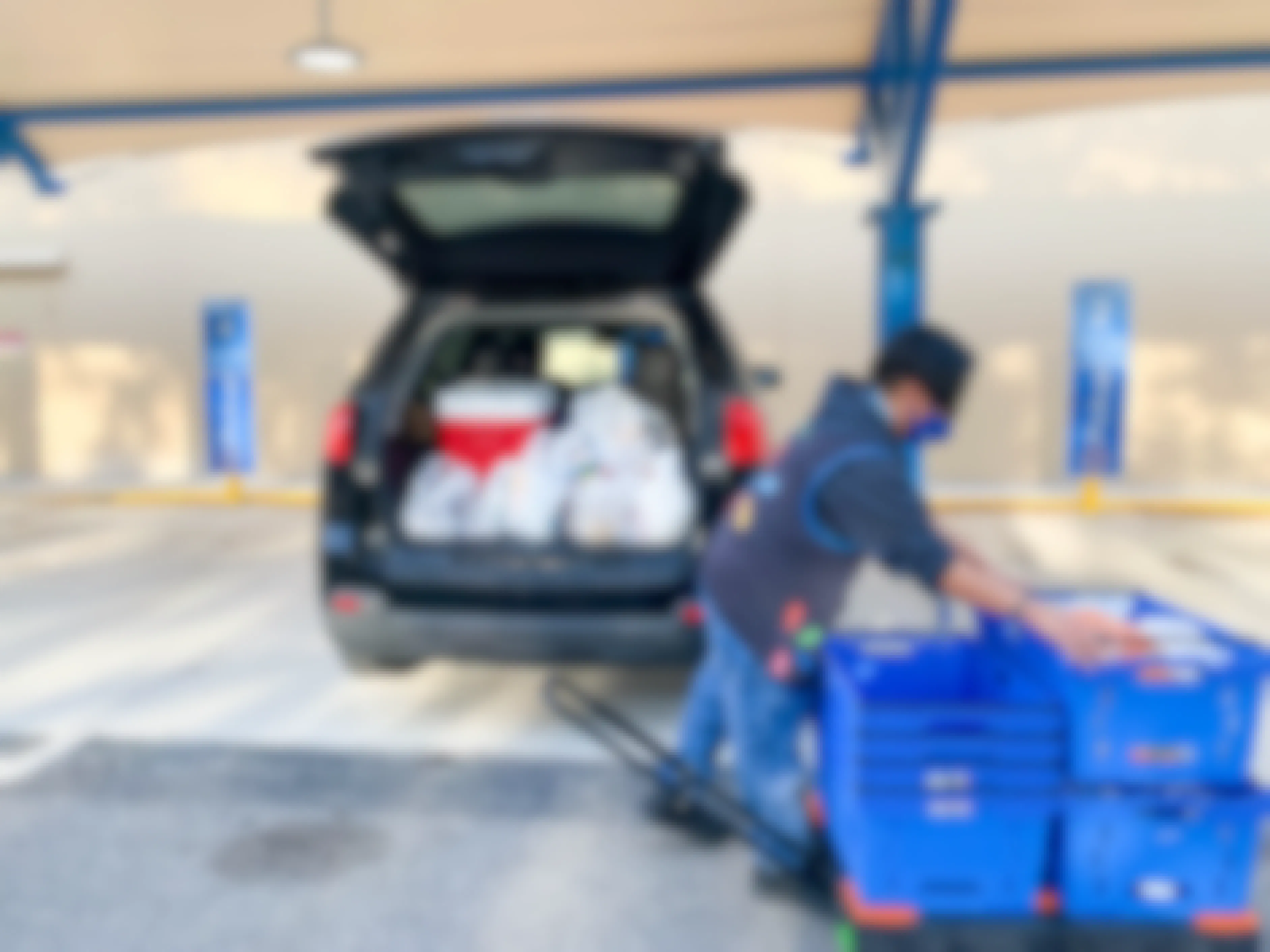 employee loading groceries in car at walmart pickup