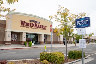 World Market store front with customer curbside pickup sign