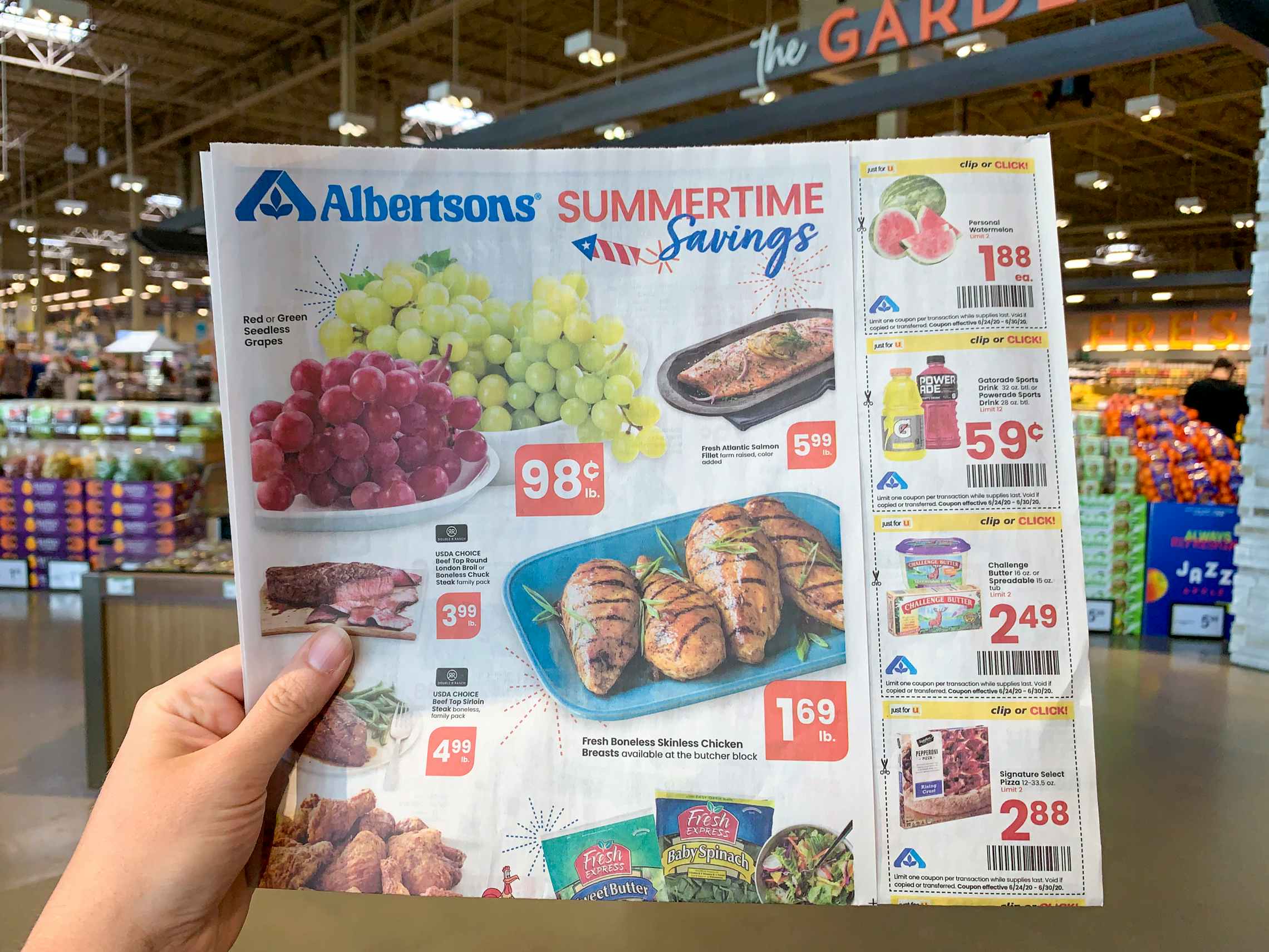 An Albertsons ad with coupons held inside a store.