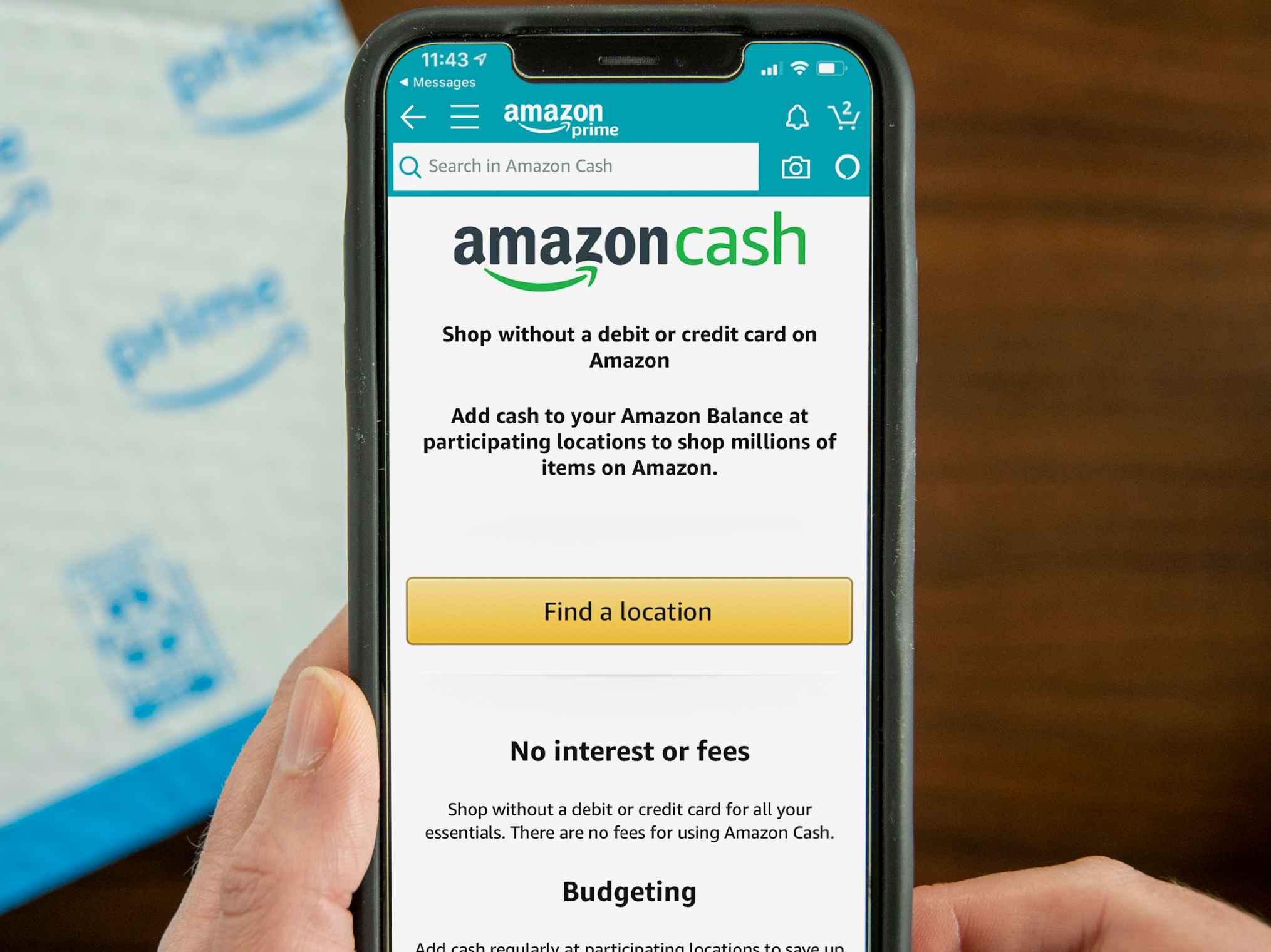 A person's hands holding up a cell phone displaying the Amazon Cash page on the Amazon mobile app.
