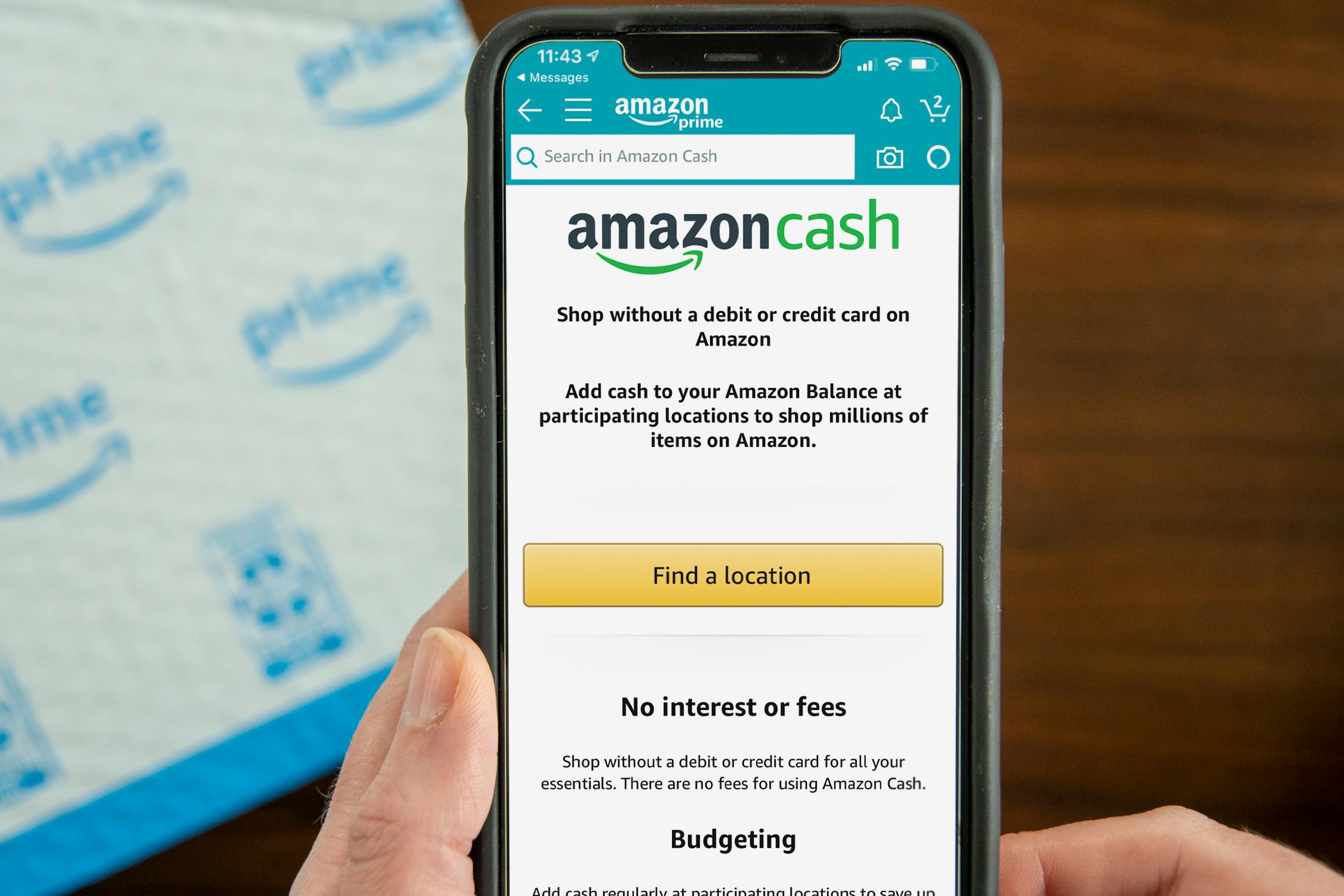 A person's hands holding up a cell phone displaying the Amazon Cash page on the Amazon mobile app.