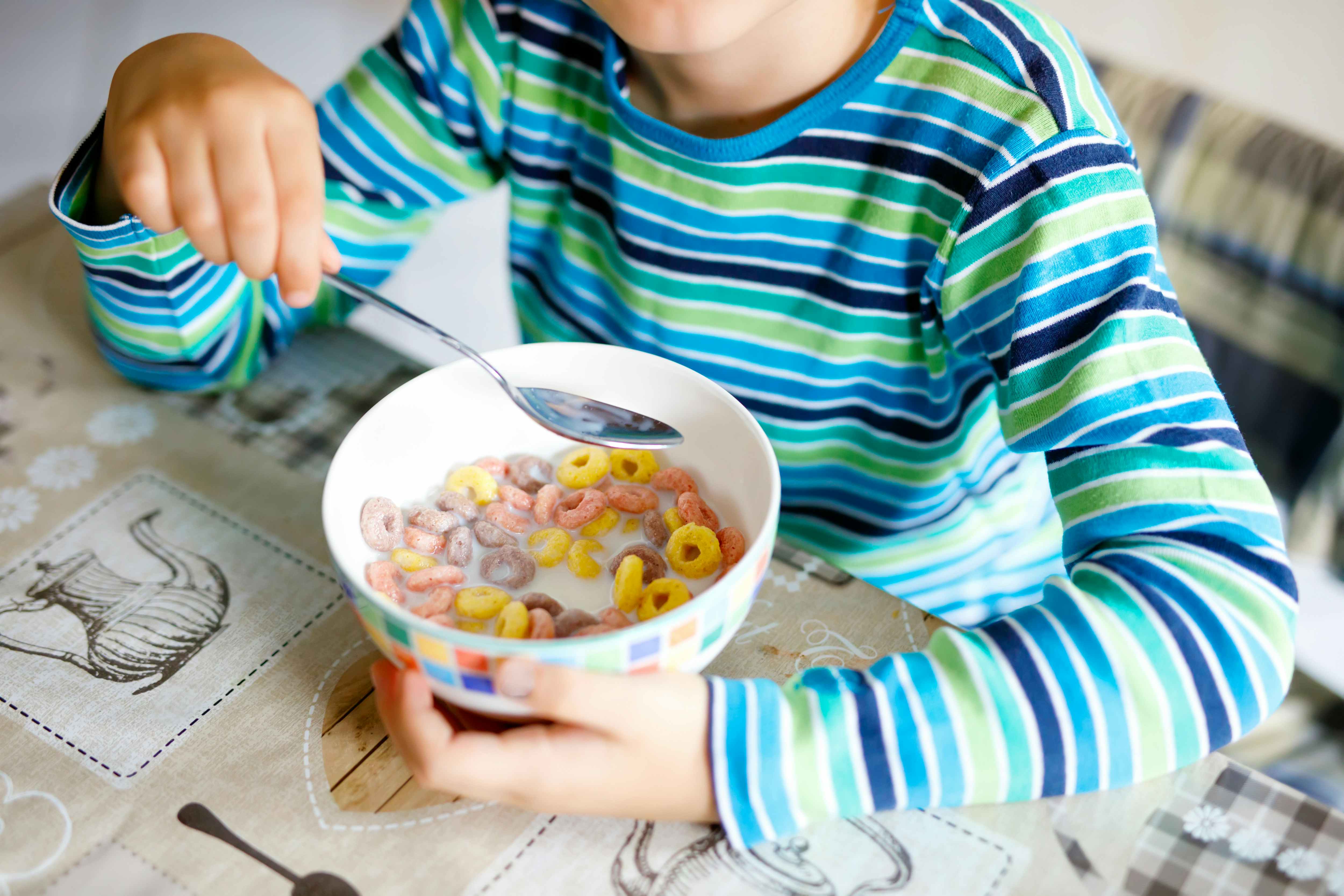 Boy eating bowl full of cereal. 