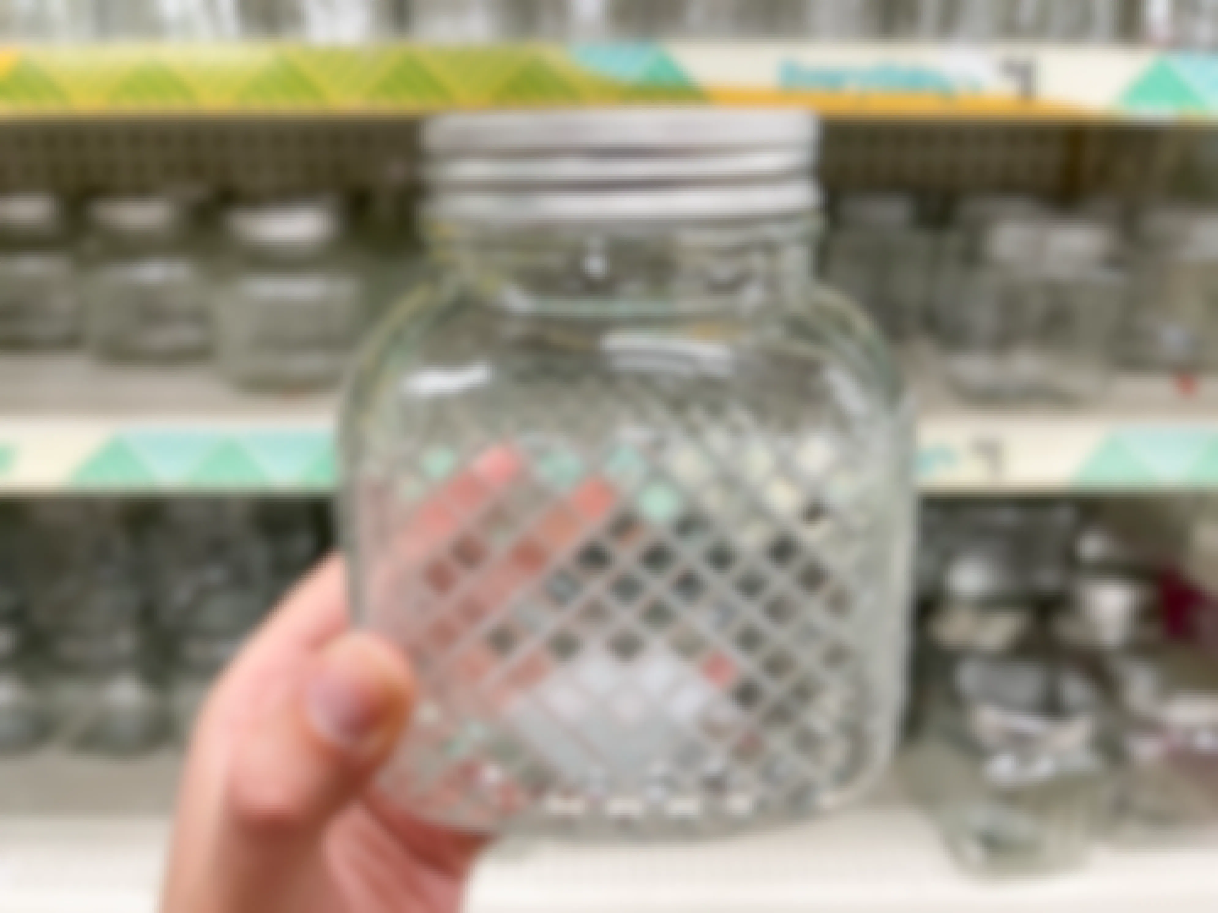A glass jar with a list, with a geometric pattern on the outside.