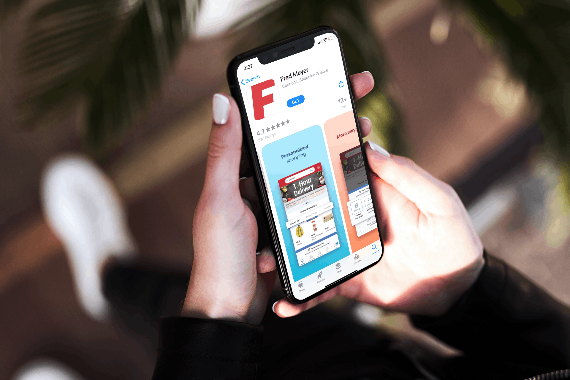 hand holds iphone with app store open and fred meyer app for download