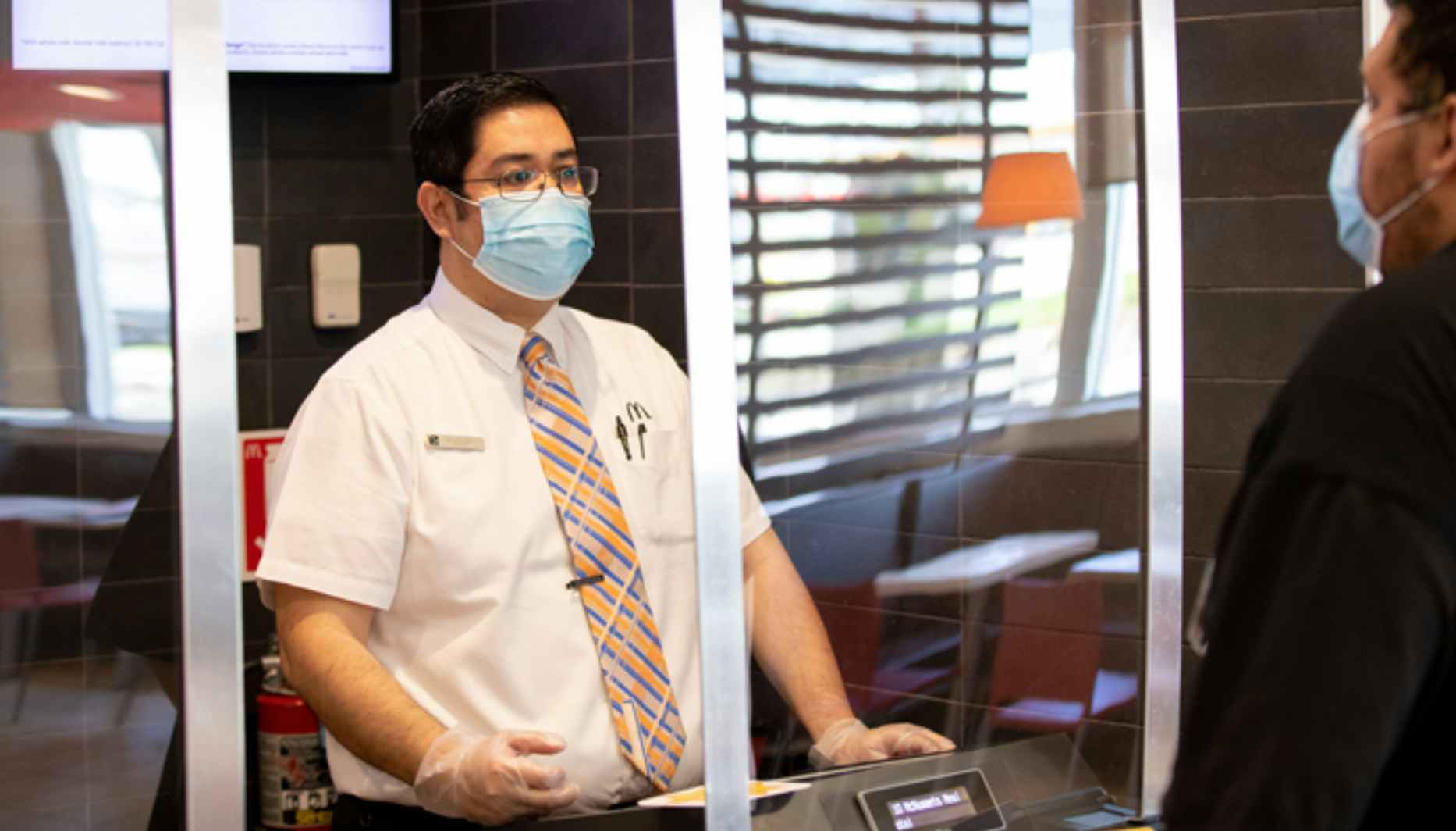 Restaurant worker at the register wearing a face mask