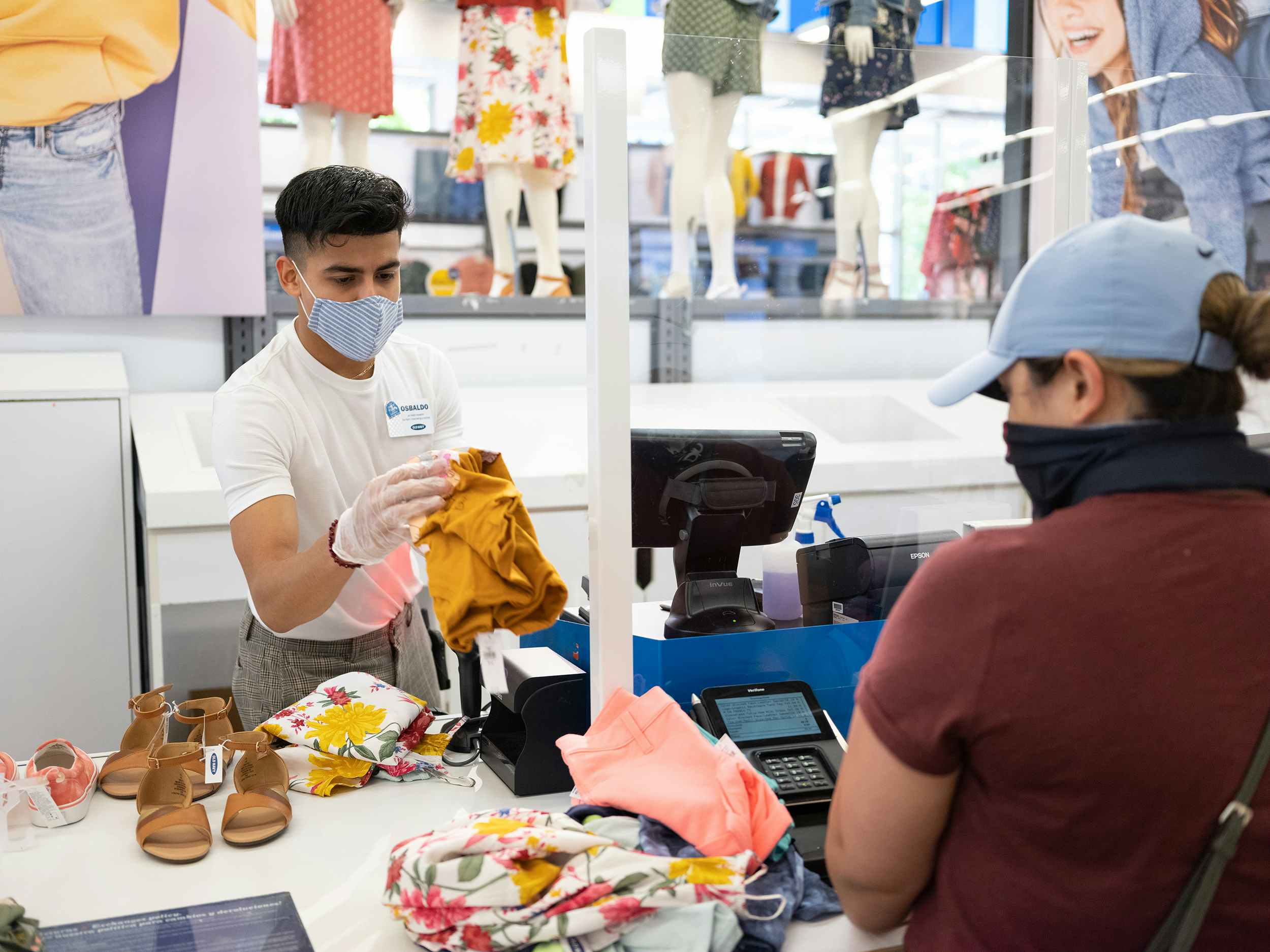old navy worker in a mask sells to customer in a mask