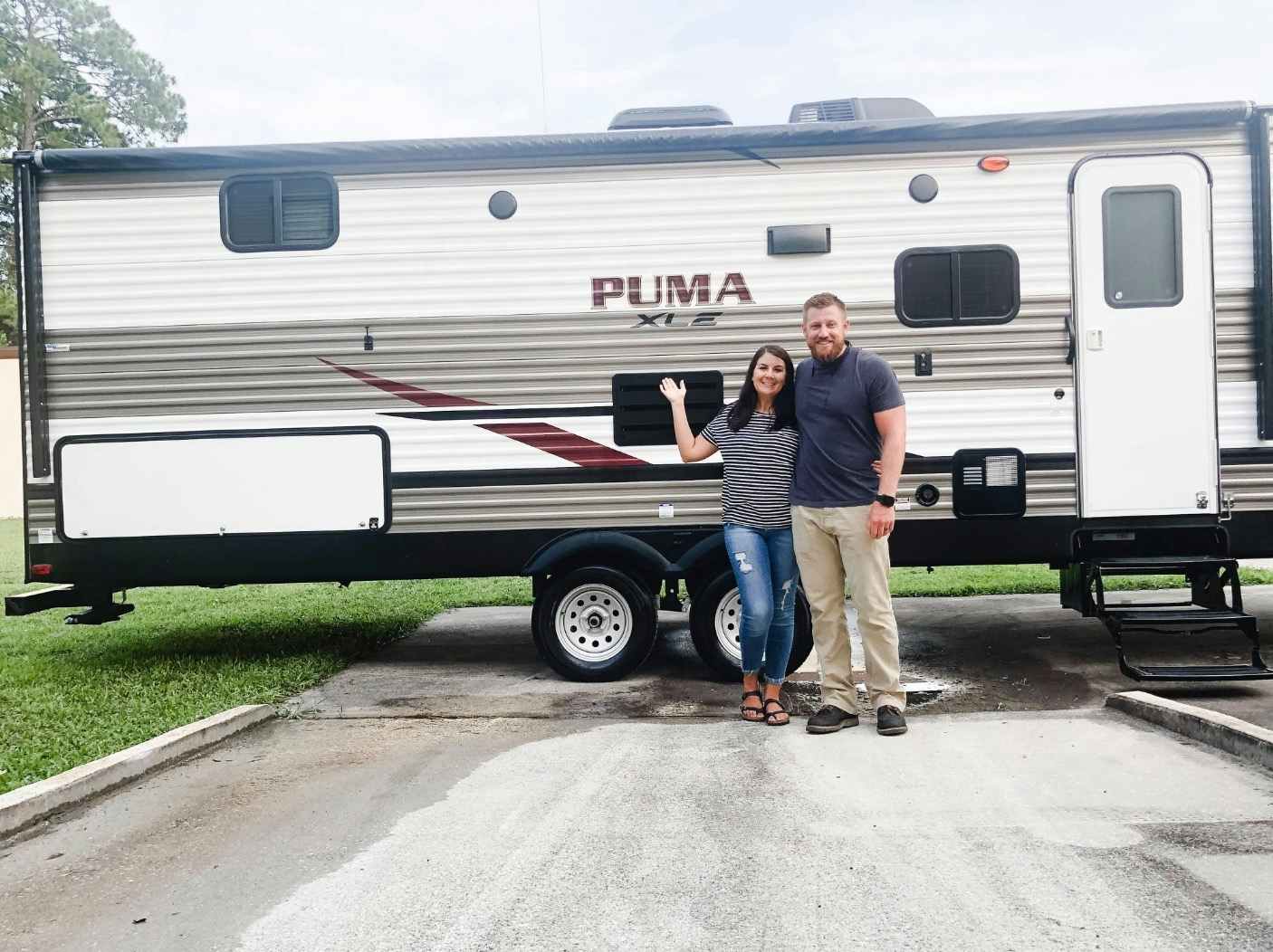 Man and woman standing in front a an RV