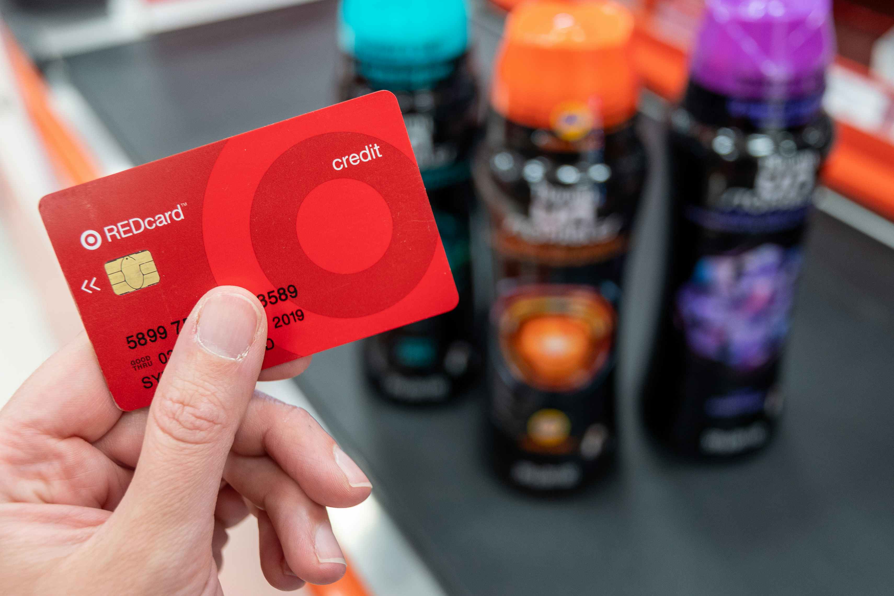 A Target red card held in front of Downy Unstopables bottles at a checkout register.