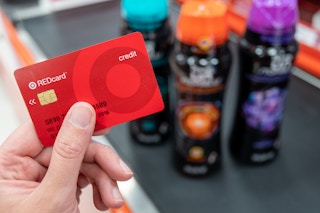 A Target red card held in front of Downy Unstopables bottles at a checkout register.