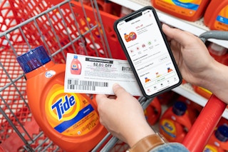 A 10% off Tide laundry detergent on the target circle app, held next to a $2 off manufacture coupon, and a bottle of Tide liquid detergent.