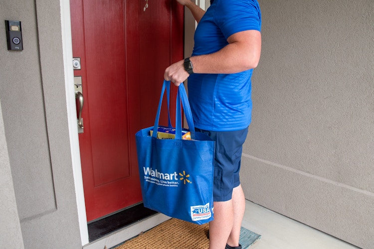 A walmart delivery employee knocking on a front door.