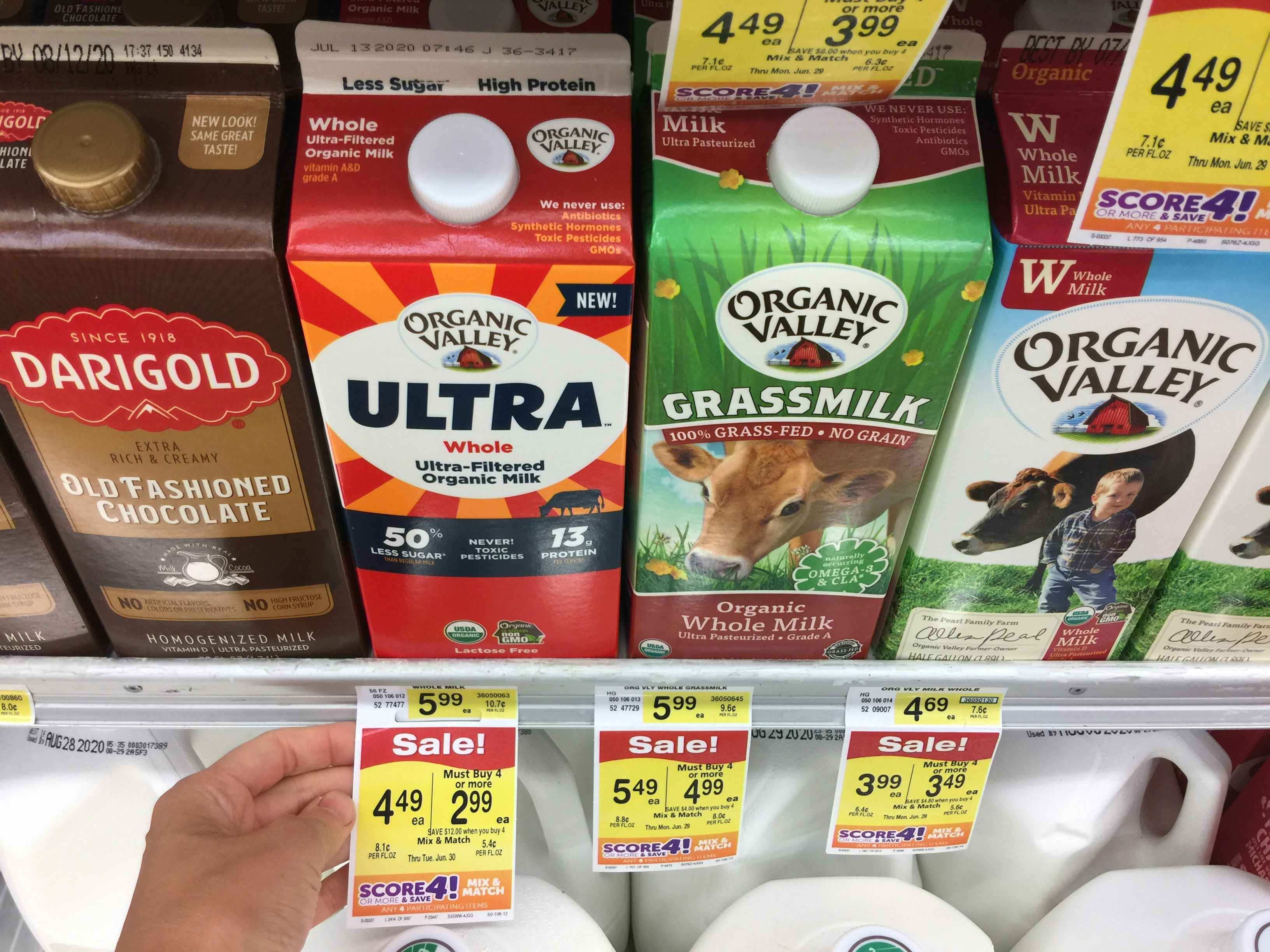 Milk and dairy products on the shelf at Albertsons with sale tags.
