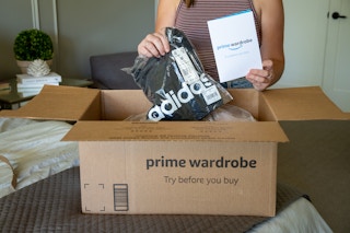 A woman pulling an adidas tank top and amazon wardrobe pamphlet from a box.