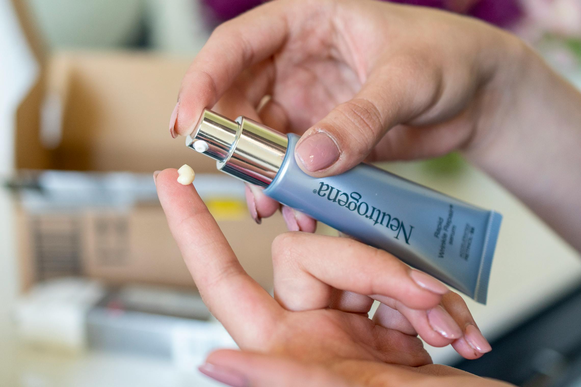 A woman putting a neutrogena product on her finger. 