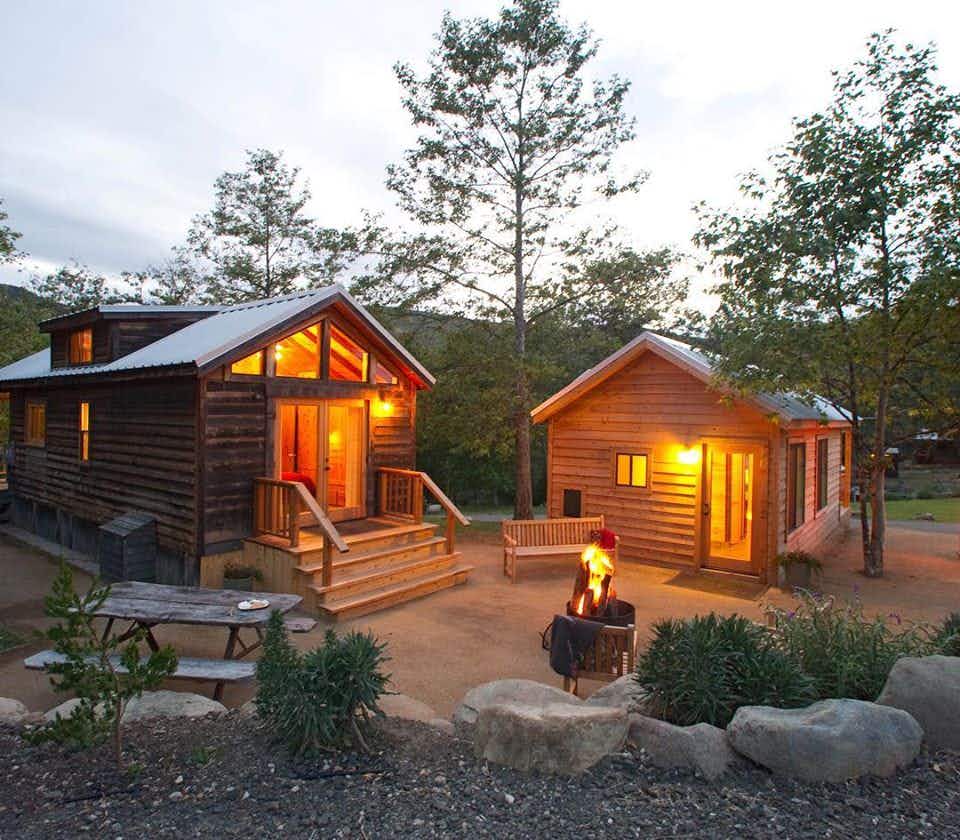 nightime cabins softly lit surround a fire ring