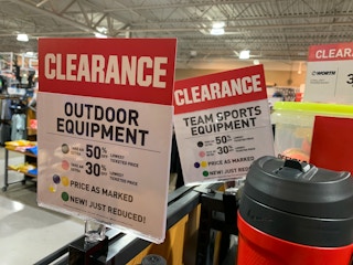 Dick's Sporting Goods clearance signs in-store for shoppers.