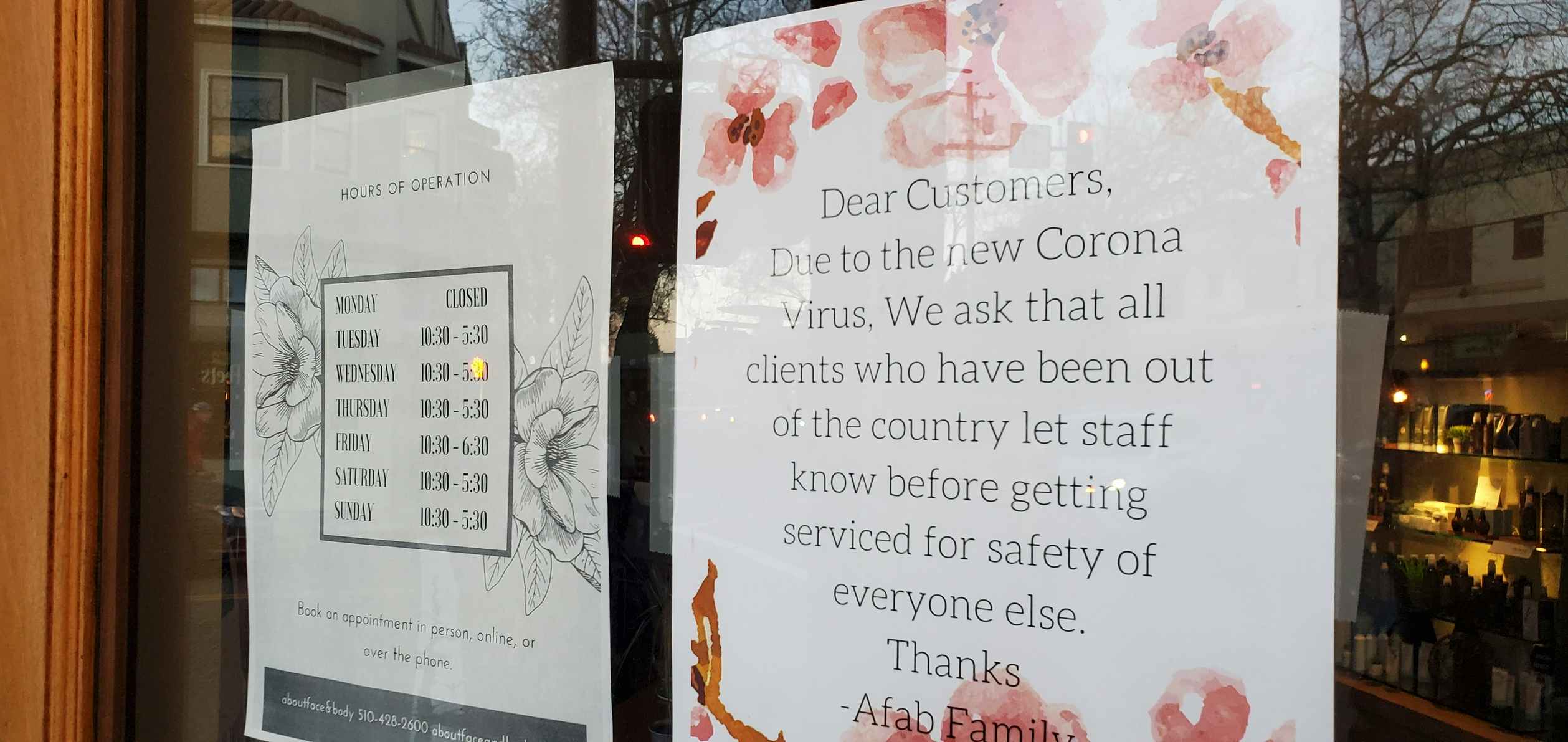 Signage on a hair salon door informing customers to notify employees if they've been out of country.