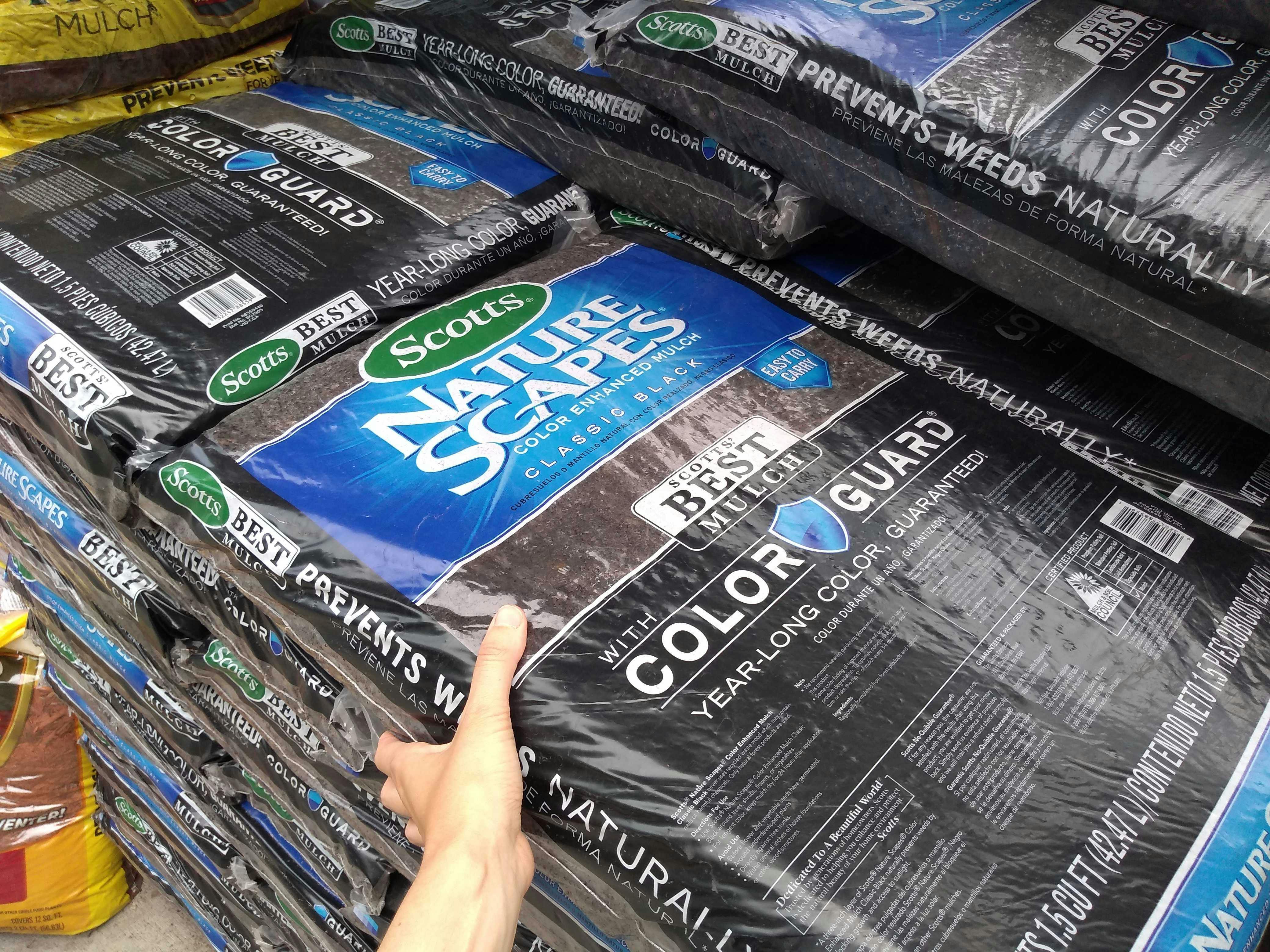 someone grabbing a bag of mulch