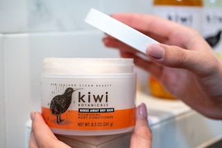 Kiwi botanicals body conditioner open in a shower.