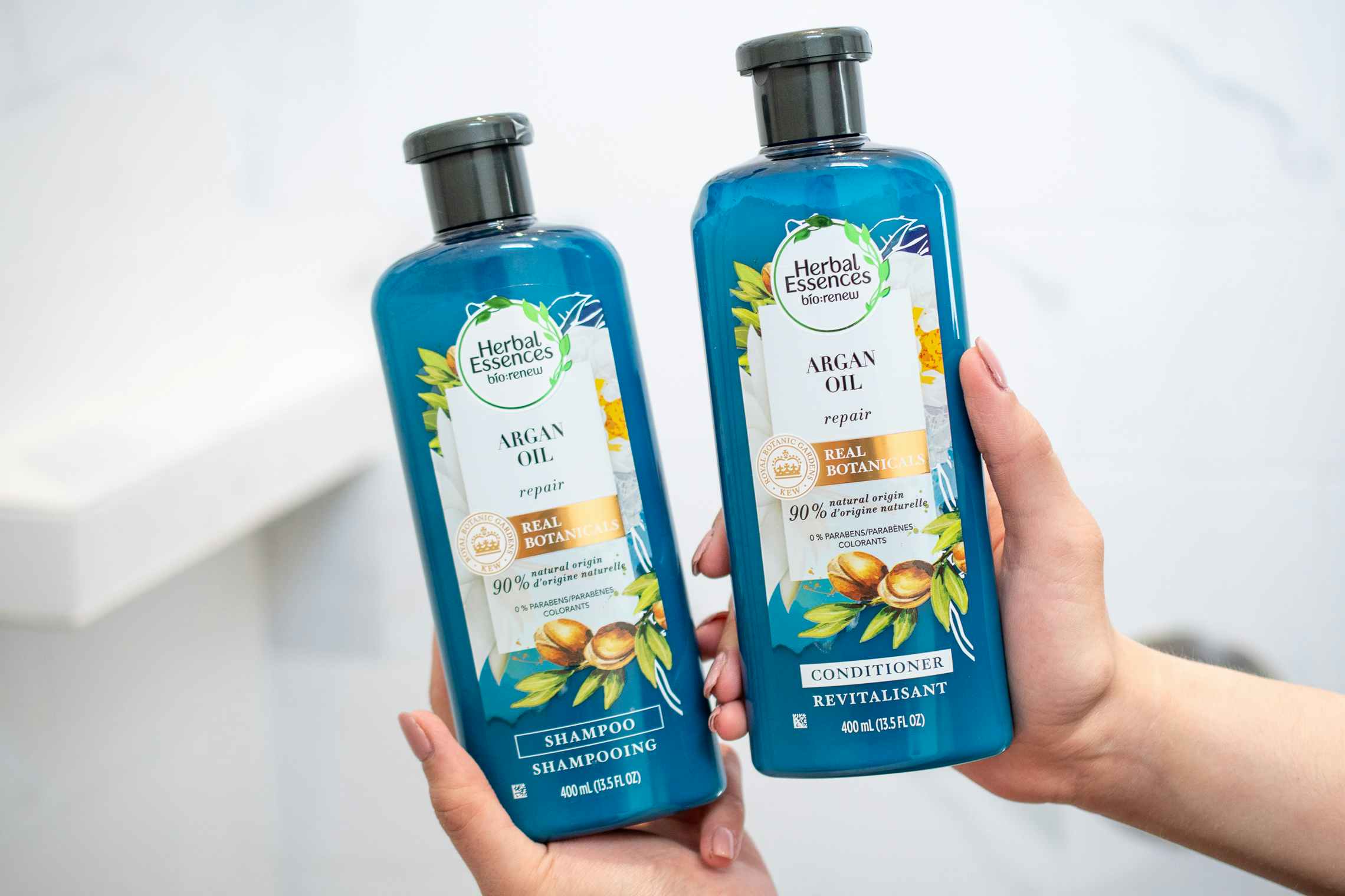 Herbal Essences shampoo and conditioner held in a shower.